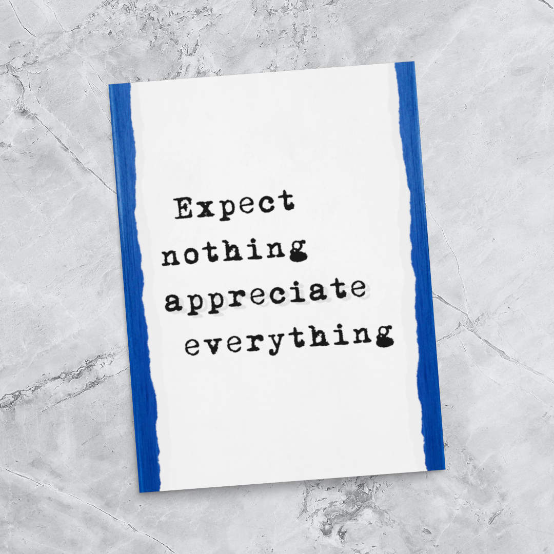 Flat lay of a motivational poster print reading “Expect Nothing Appreciate Everything” in black typewriter-style text with blue torn-edge borders, displayed on a textured marble background—ideal for stylish and meaningful wall art decor.