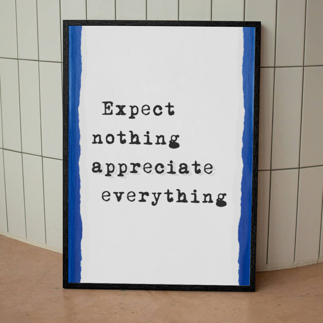 Framed motivational wall art poster with the quote “Expect Nothing Appreciate Everything” in a typewriter font, styled with blue torn-edge borders, leaning against a tiled wall – perfect for home, office, or mindful decor inspiration.