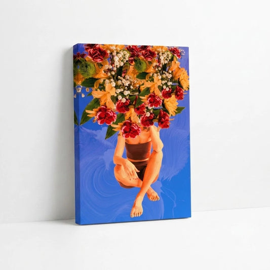 A vertical canvas wall art print leaning against a white wall on a white surface. The artwork depicts a crouching figure with bare legs and feet, with a large floral arrangement in red, orange, yellow, and white replacing the head.