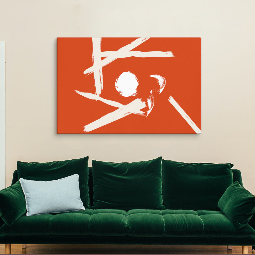 A striking orange and white abstract canvas print is mounted above a deep green velvet sofa, creating a bold contrast. The combination of rich jewel tones and modern abstract art makes this living space feel inviting and artistic.