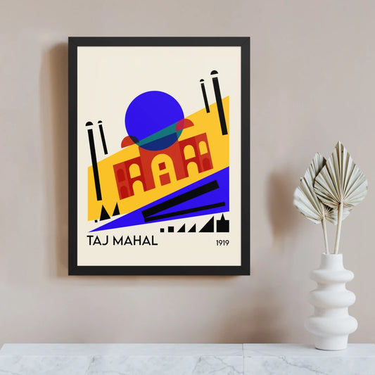 Bauhaus Taj Mahal art print in a black frame, with the Indian monument reimagined as a tilted composition of yellow, red and blue planes, a bold blue dome and black minaret lines.