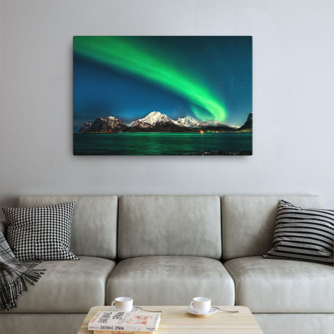 Mockup image of the artwork "Celestial Dance of the Aurora Canvas Print" depicting a mesmerizing aurora borealis illuminating snowy peaks. The vibrant colors of the aurora dance across the dark sky, creating a captivating and ethereal display.