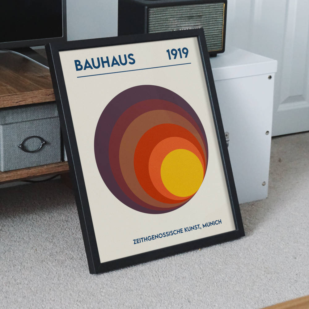 Bauhaus Sunrise wall art in black frame – vintage modernist design featuring warm concentric circles from 1919.