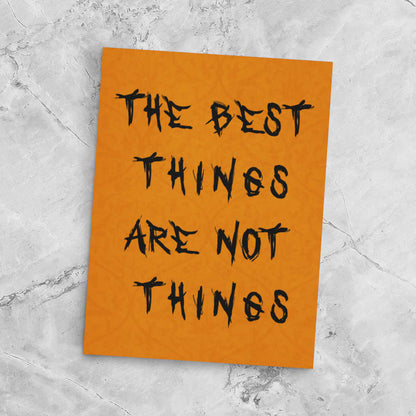 Orange poster with black text 'The best things are not things' on a gray marble background