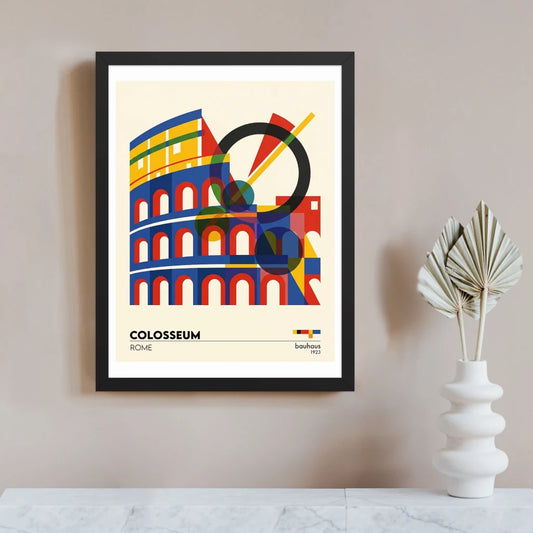 Bauhaus-style Colosseum art print in a black frame, showing Rome’s amphitheatre as bold geometric shapes in red, blue and yellow with a black circle and diagonal line accents on a cream background.