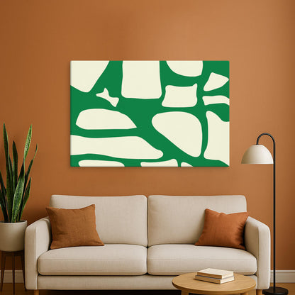A bold green and white abstract canvas print is centered above a beige sofa in a warm-toned living room. The organic shapes in the artwork contrast beautifully with the earthy orange walls and matching decor.