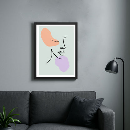 A modern minimalist interior featuring a black framed abstract line art print on a gray wall. The print contains soft peach and lavender shapes with delicate curved lines. Below is a dark gray or black sofa with a cushion, a small potted plant, and a sleek black floor lamp with a rounded shade.