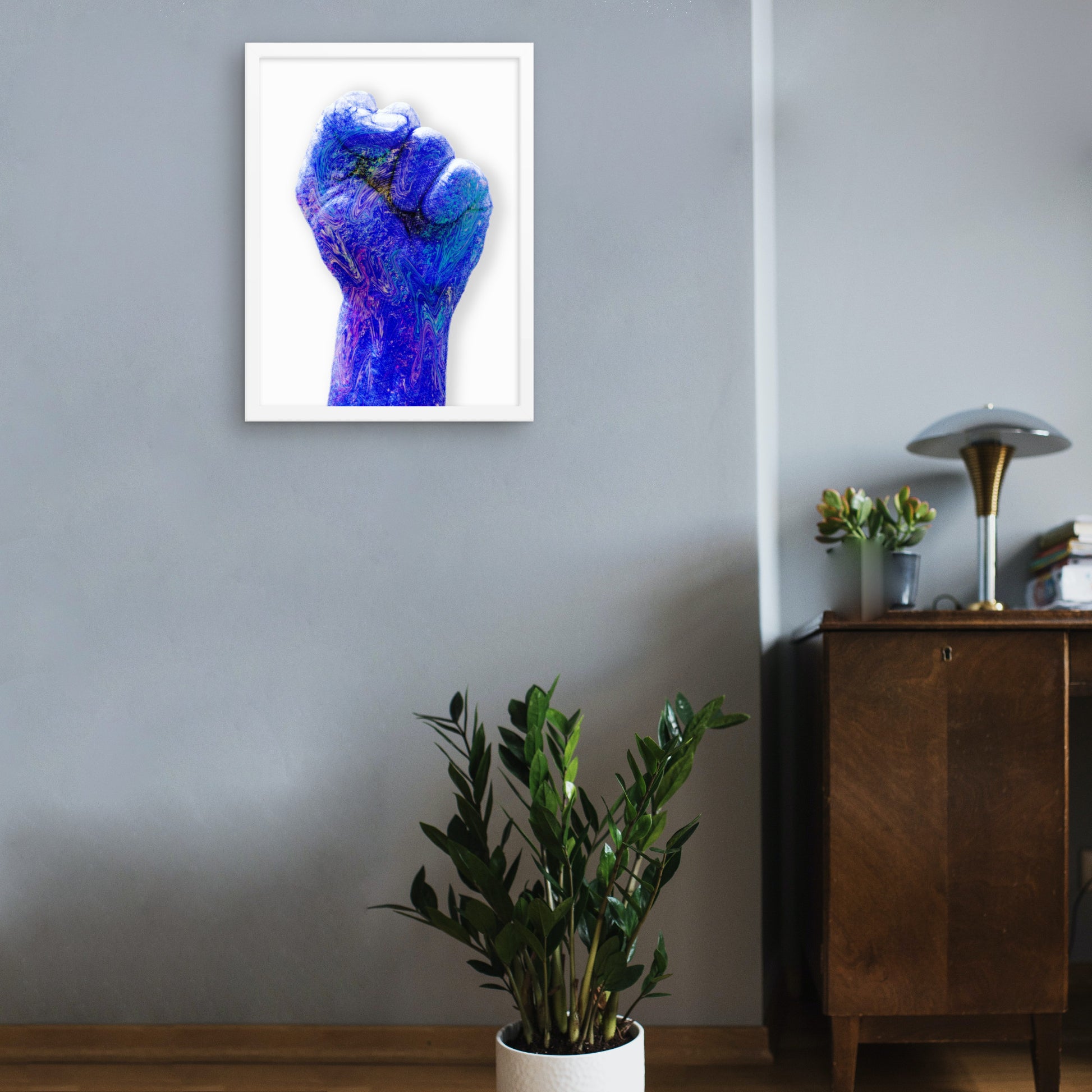 Blue raised fist in white frame wall art print on wall 